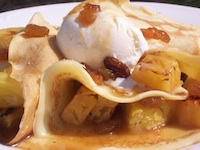 grilled pineapple inside crepes with rum raisin sauce